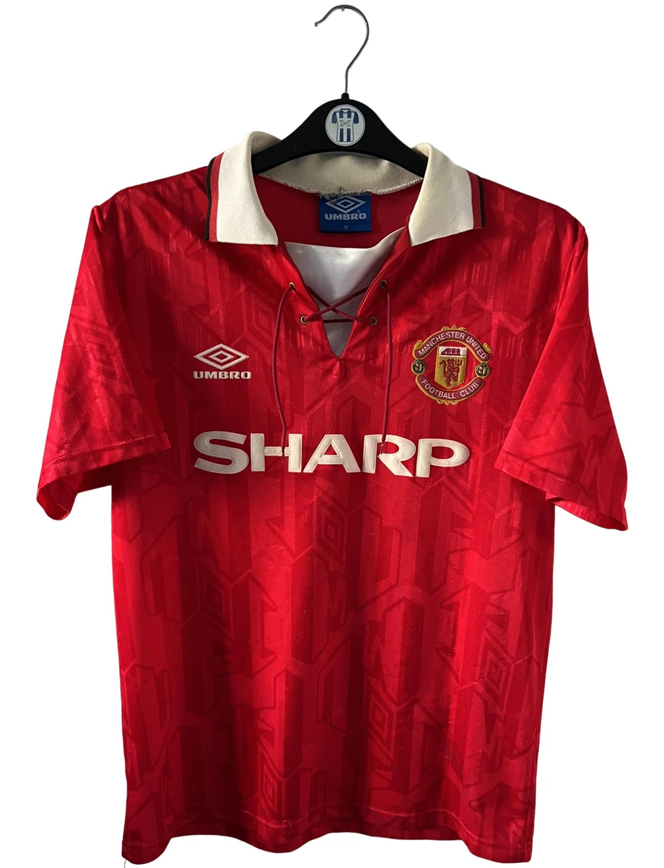 Maillot de foot vintage domicile rouge de manchester united 1992/1994. On peut retrouver l'équipementier umbro et le sponsor Sharp. Il s'agit d'un maillot authentique d'époque.