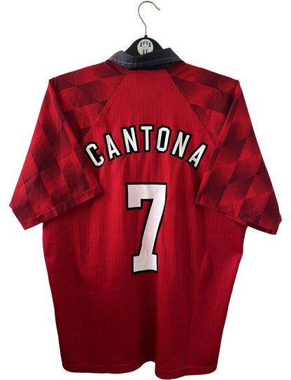 Maillot de foot vintage domicile rouge de Manchester United 1996/1998. On peut retrouver l'équipementier Umbro et le sponsor Sharp. Le maillot est floqué du numéro 7 Eric Cantona. Il s'agit d'un maillot authentique d'époque.