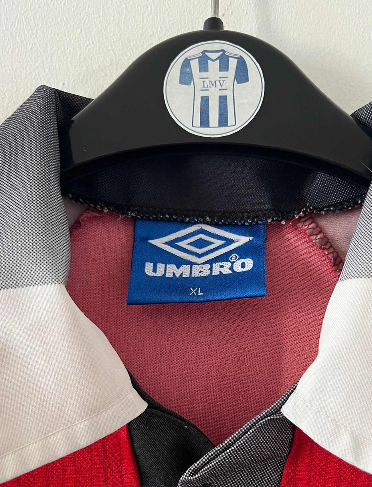 Maillot de foot vintage domicile rouge de Manchester United 1996/1998. On peut retrouver l'équipementier Umbro et le sponsor Sharp. Le maillot est floqué du numéro 7 Eric Cantona. Il s'agit d'un maillot authentique d'époque.