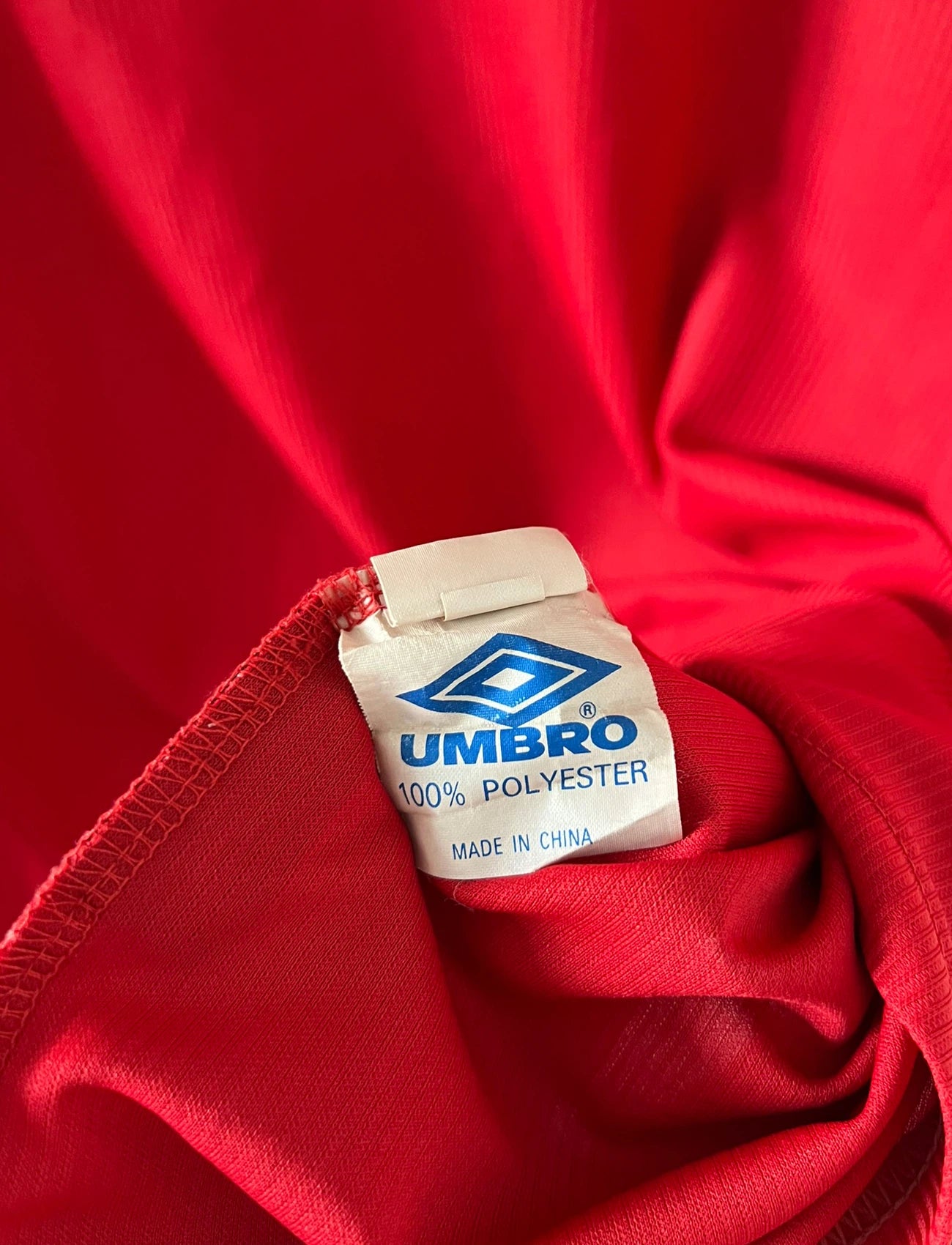 Maillot de foot vintage domicile rouge de Manchester United saison 1998/2000. On peut retrouver l'équipementier Umbro et le sponsor Sharp. Il s'agit d'un maillot authentique d'époque.