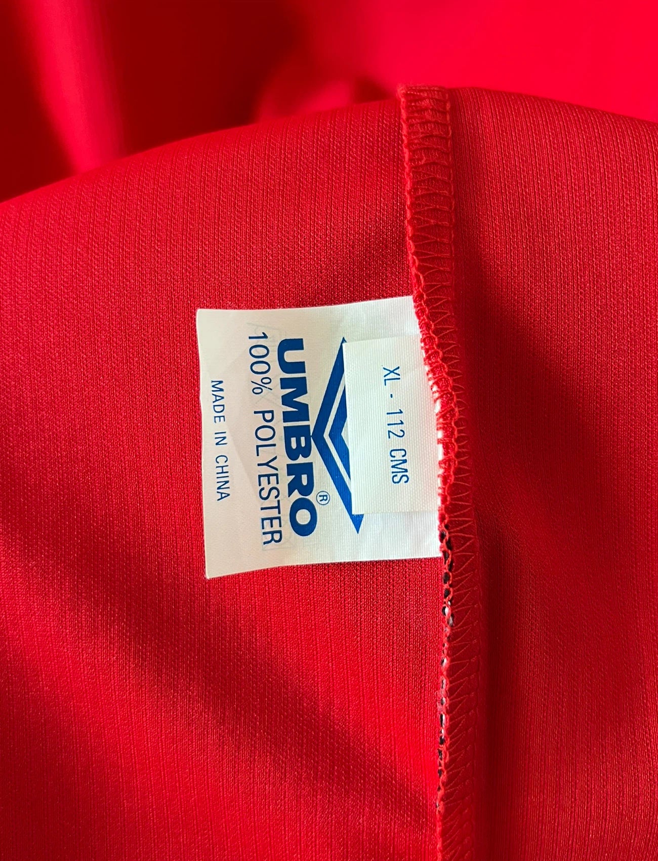 Maillot de foot vintage domicile rouge de Manchester United saison 1998/2000. On peut retrouver l'équipementier Umbro et le sponsor Sharp. Il s'agit d'un maillot authentique d'époque.