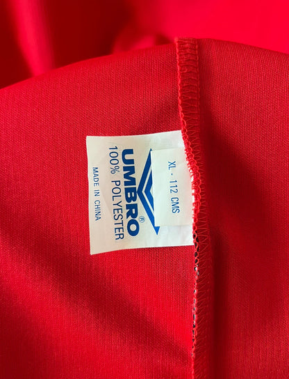 Maillot de foot vintage domicile rouge de Manchester United saison 1998/2000. On peut retrouver l'équipementier Umbro et le sponsor Sharp. Il s'agit d'un maillot authentique d'époque.