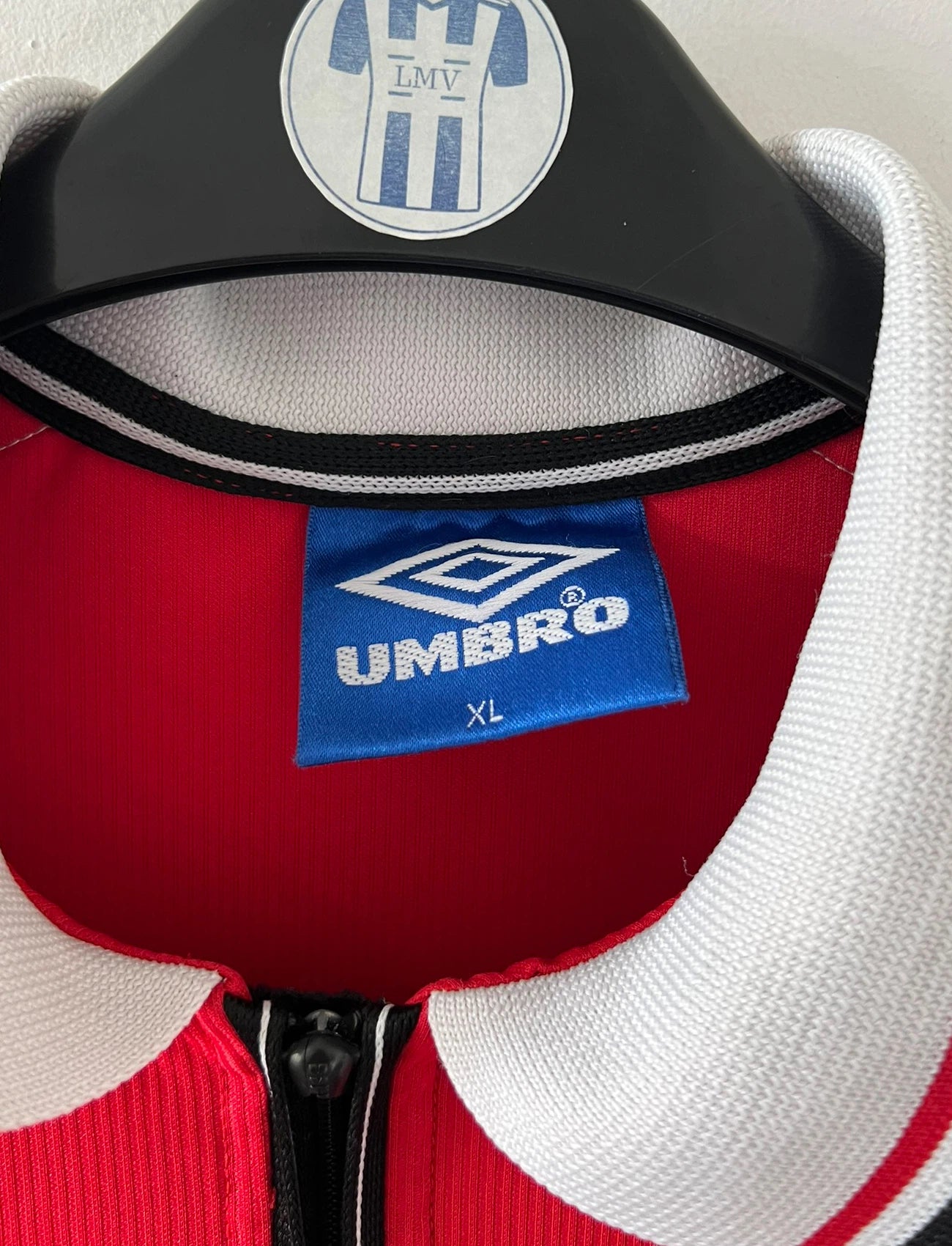 Maillot foot vintage domicile rouge de Manchester United 1998. On peut retrouver l'équipementier Umbro et le sponsor Sharp. Il s'agit d'un maillot authentique d'époque.