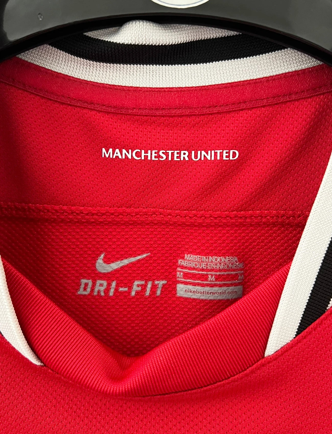 Maillot de foot vintage domicile rouge de Manchester United 2011/2012. On peut retrouver l'équipementier Nike et le sponsor Aon. Il s'agit d'un maillot authentique d'époque.