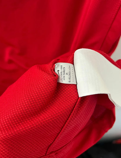 Maillot de foot vintage domicile rouge de Manchester United 2011/2012. On peut retrouver l'équipementier Nike et le sponsor Aon. Il s'agit d'un maillot authentique d'époque.