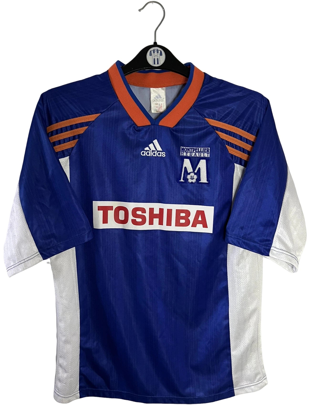 Maillot de foot vintage domicile bleu de Montpellier de la saison 1999/2000. On peut retrouver l'équipementier Adidas et le sponsor Toshiba. Il s'agit d'un maillot authentique d'époque.