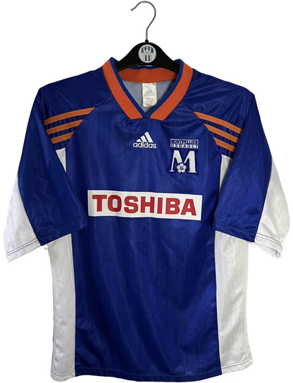Maillot de foot vintage domicile bleu de Montpellier de la saison 1999/2000. On peut retrouver l'équipementier Adidas et le sponsor Toshiba. Il s'agit d'un maillot authentique d'époque.