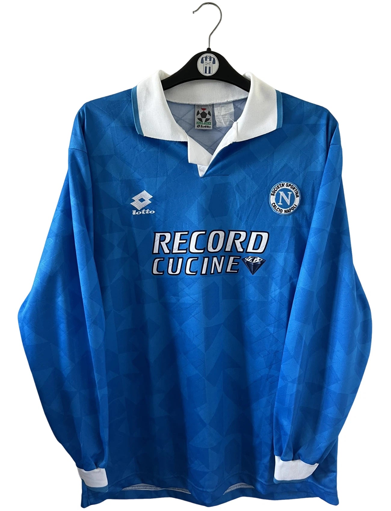Maillot de foot vintage domicile bleu du Napoli de la saison 1994/1996. On peut retrouver l'équipementier Lotto et le sponsor Record Cucine. Il s'agit d'un maillot authentique d'époque.