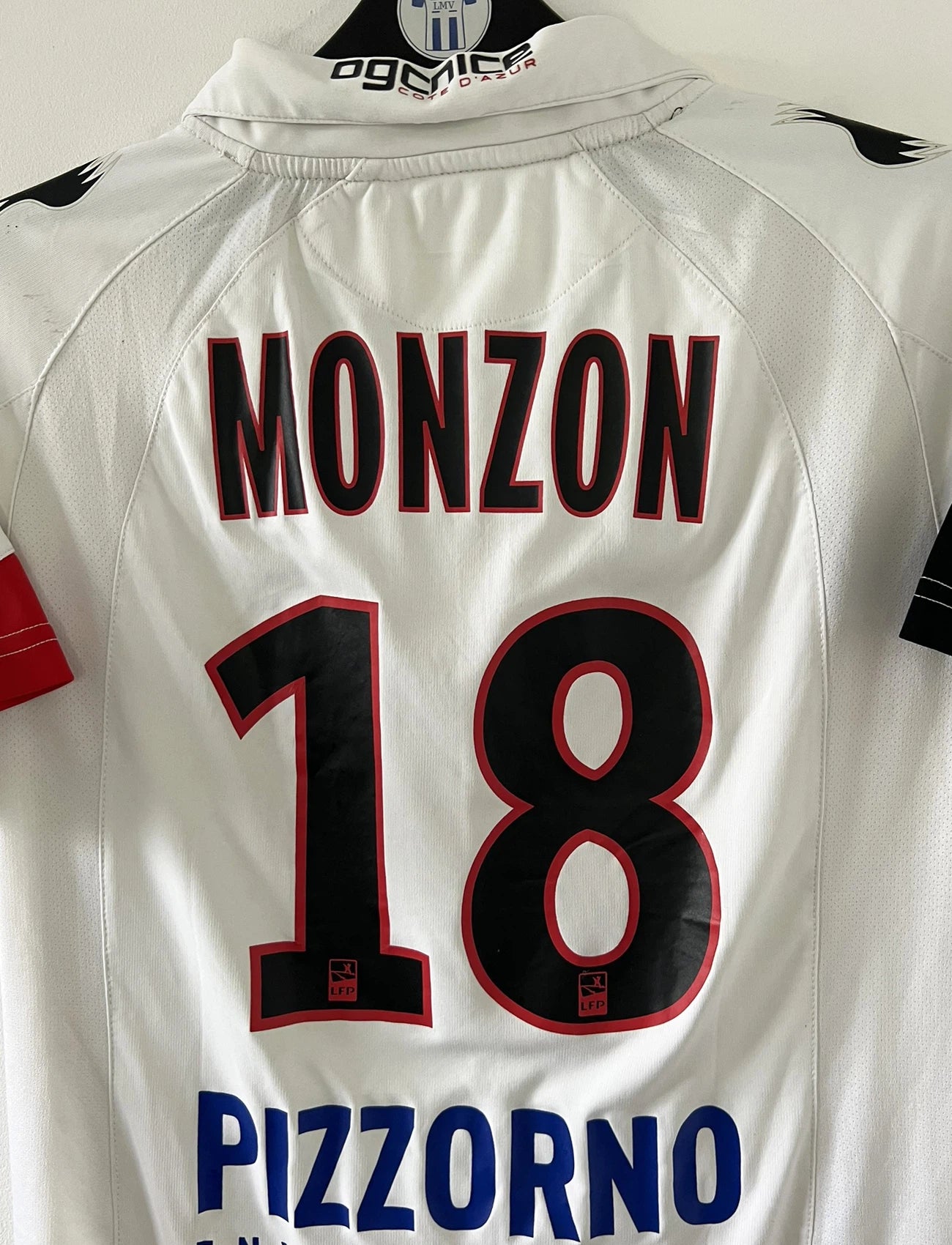 Maillot de foot vintage extérieur blanc de l'OGC Nice porté par Fabian Monzon lors de la saison 2011/2012. On peut retrouver l'équipementier Burrda Sport et le sponsor Mutuelle du Soleil. Le maillot est floqué du numéro 18 Fabian Monzon. Il s'agit d'un maillot authentique d'époque.