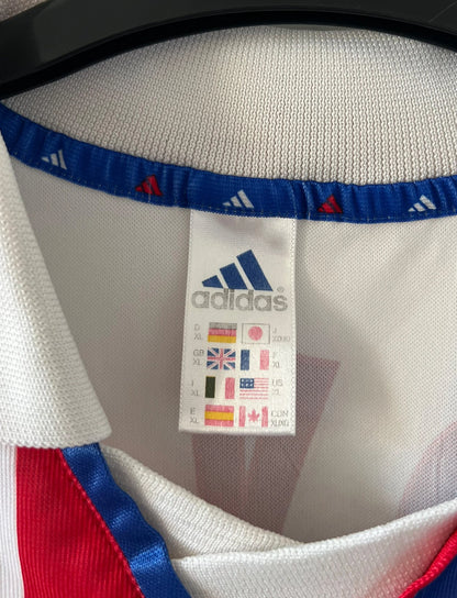 Maillot de foot vintage domicile blanc de l'OL 2000/2001. On peut retrouver l'équipementier Adidas et le sponsor Continental. Le maillot est floqué du numéro 14 Sidney Govou. Il s'agit d'un maillot authentique d'époque.