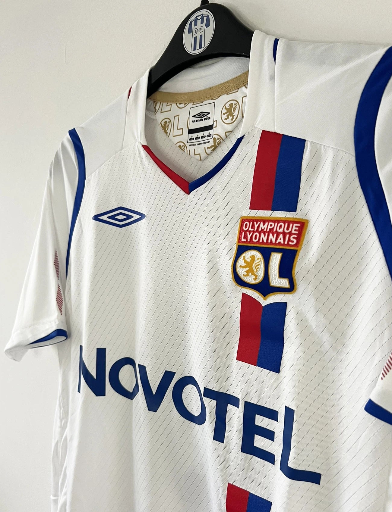 Maillot de foot vintage domicile blanc de l'OL de la saison 2008/2009. On peut retrouver l'équipementier Umbro et le sponsor Novotel. Le maillot est floqué du numéro 8 Juninho. Il s'agit d'un maillot authentique d'époque.