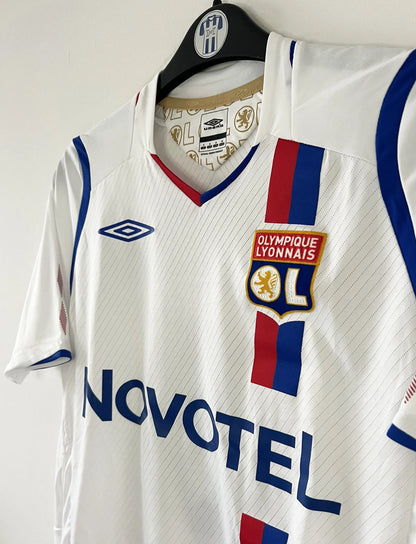 Maillot de foot vintage domicile blanc de l'OL de la saison 2008/2009. On peut retrouver l'équipementier Umbro et le sponsor Novotel. Le maillot est floqué du numéro 8 Juninho. Il s'agit d'un maillot authentique d'époque.