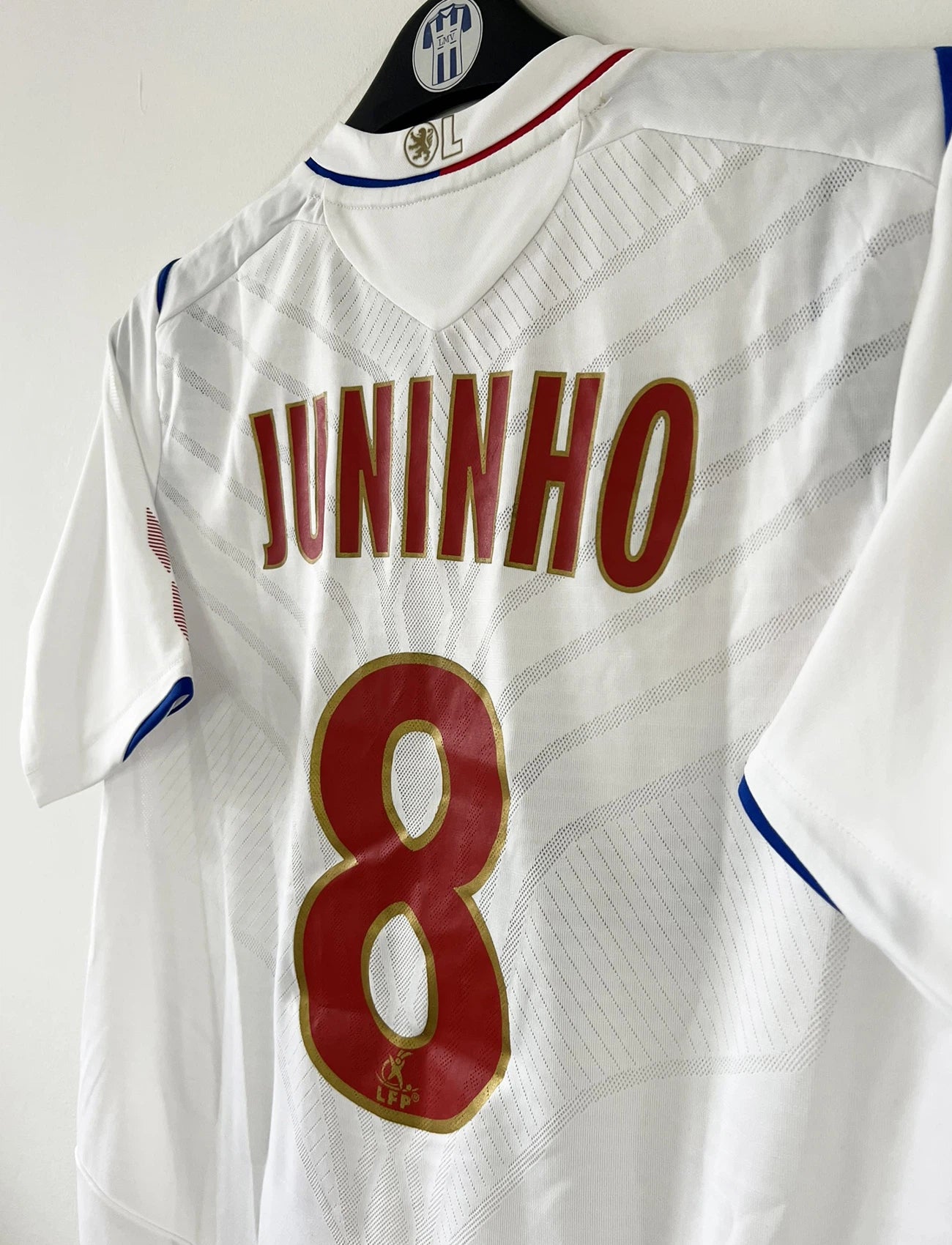 Maillot de foot vintage domicile blanc de l'OL de la saison 2008/2009. On peut retrouver l'équipementier Umbro et le sponsor Novotel. Le maillot est floqué du numéro 8 Juninho. Il s'agit d'un maillot authentique d'époque.