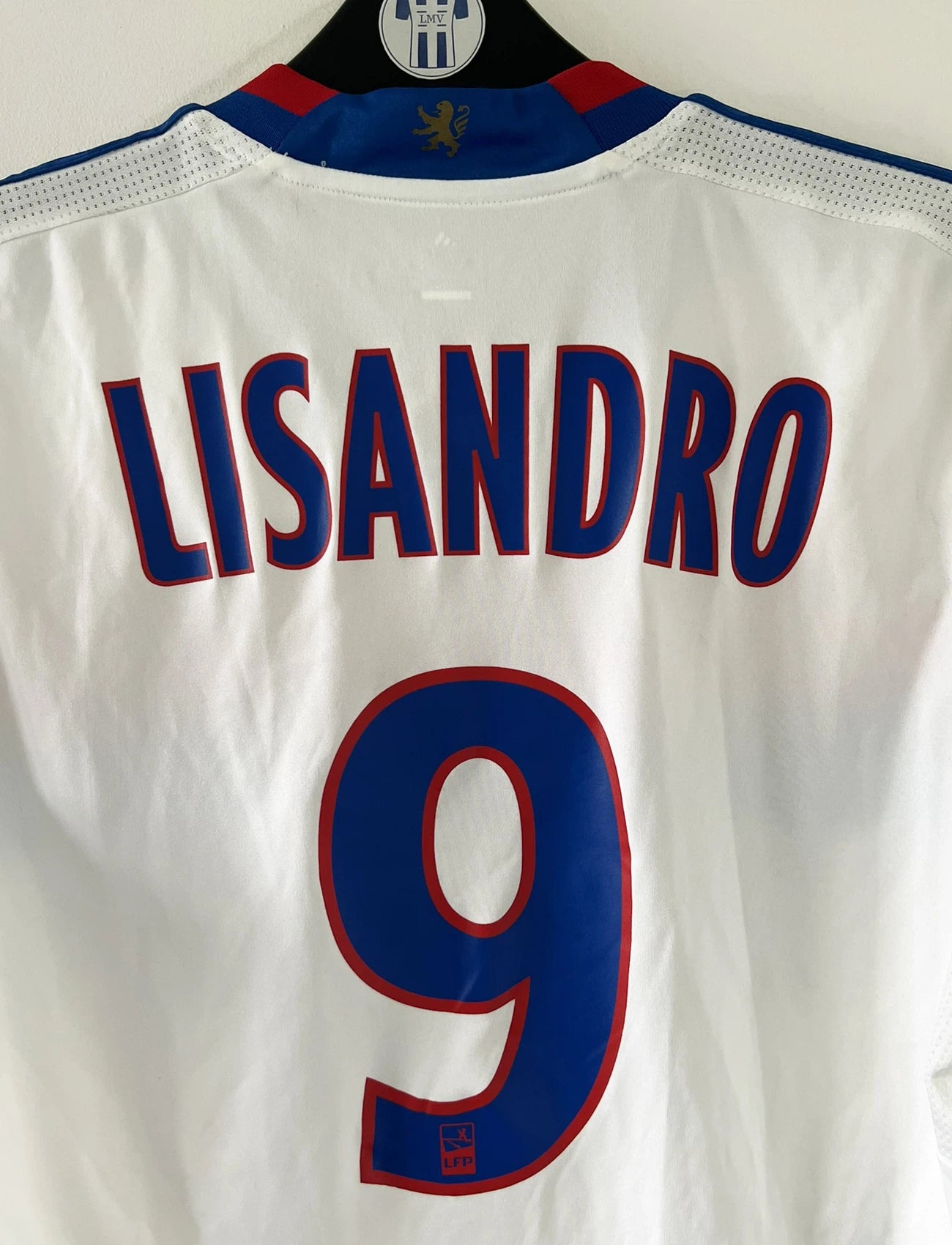 Maillot de foot vintage domicile de l'OL de la saison 2011/2012. On peut retrouver l'équipementier Adidas et le sponsor Everest Poker. Le maillot est floqué du numéro 9 Lisandro Lopez. Il s'agit d'un maillot authentique d'époque comportant les numéro V13375.