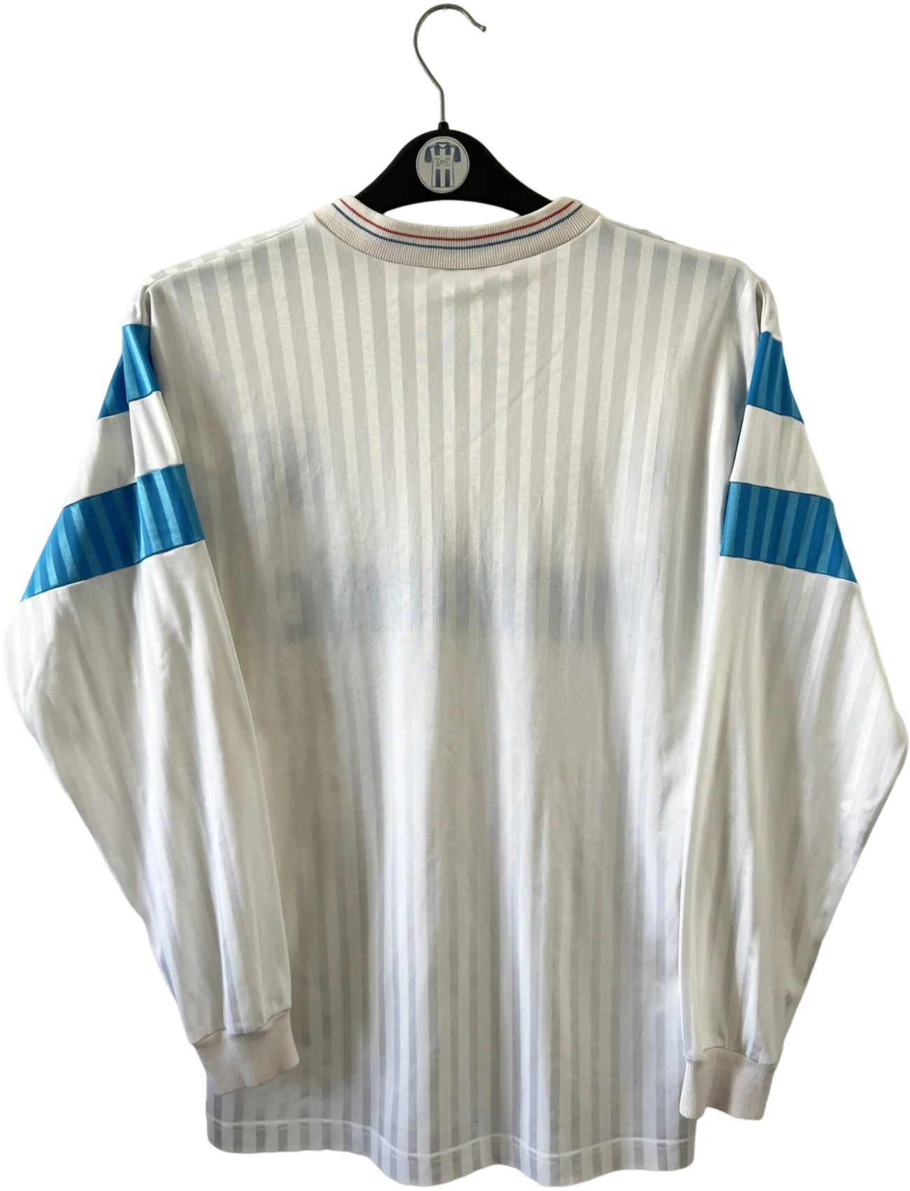 Maillot de foot vintage domicile blanc de l'OM 1989/1991. On peut retrouver l'équipementier Adidas et le sponsor Panasonic. Il s'agit d'un maillot authentique d'époque.