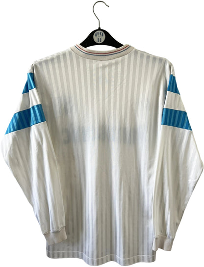 Maillot de foot vintage domicile blanc de l'OM 1989/1991. On peut retrouver l'équipementier Adidas et le sponsor Panasonic. Il s'agit d'un maillot authentique d'époque.