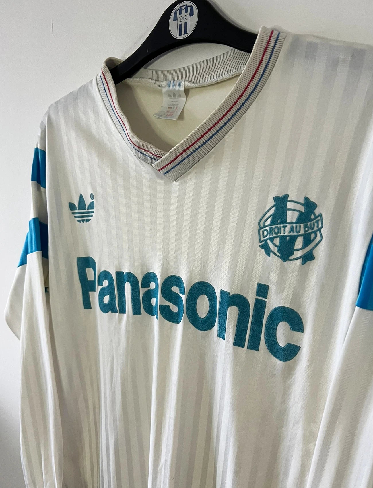 Maillot de foot vintage domicile blanc de l'OM 1989/1991. On peut retrouver l'équipementier Adidas et le sponsor Panasonic. Il s'agit d'un maillot authentique d'époque.