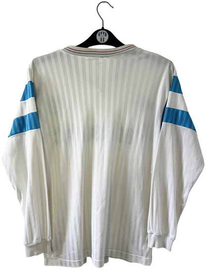 Maillot de foot vintage domicile blanc de l'OM 1989/1991. On peut retrouver l'équipementier Adidas et le sponsor Panasonic. Il s'agit d'un maillot authentique d'époque.