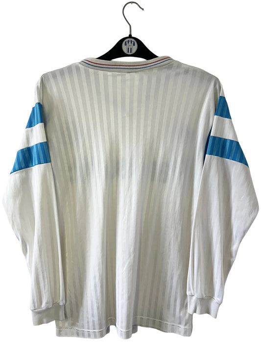 Maillot de foot vintage domicile blanc de l'OM 1989/1991. On peut retrouver l'équipementier Adidas et le sponsor Panasonic. Il s'agit d'un maillot authentique d'époque.