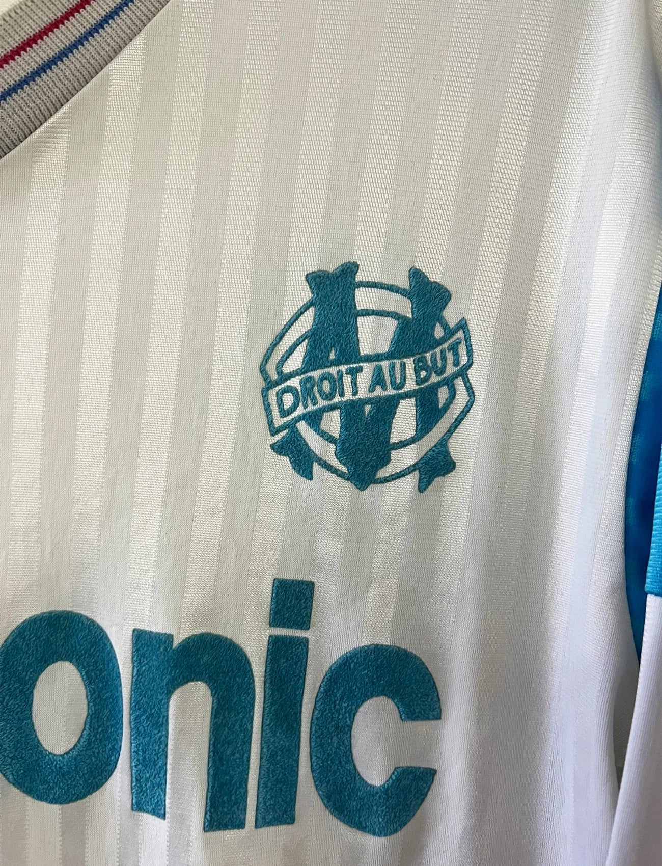 Maillot de foot vintage domicile blanc de l'OM 1989/1991. On peut retrouver l'équipementier Adidas et le sponsor Panasonic. Il s'agit d'un maillot authentique d'époque.