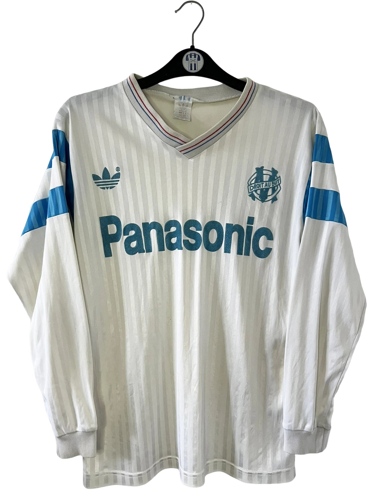 Maillot de foot vintage domicile blanc de l'OM 1989/1991. On peut retrouver l'équipementier Adidas et le sponsor Panasonic. Il s'agit d'un maillot authentique d'époque.