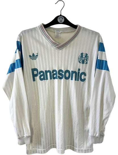 Maillot de foot vintage domicile blanc de l'OM 1989/1991. On peut retrouver l'équipementier Adidas et le sponsor Panasonic. Il s'agit d'un maillot authentique d'époque.