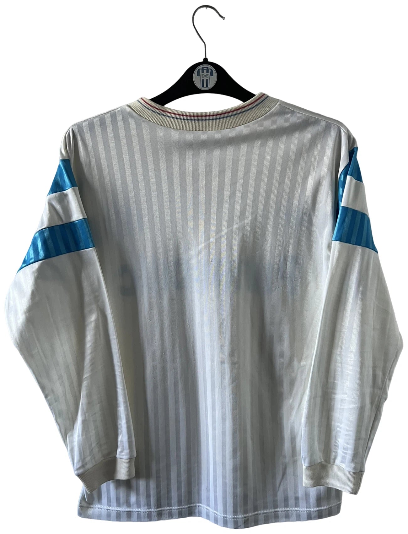 Maillot foot vintage domicile blanc de l'OM 1989/1991. On peut retrouver l'équipementier Adidas et le sponsor Panasonic. Il s'agit d'un maillot authentique d'époque.