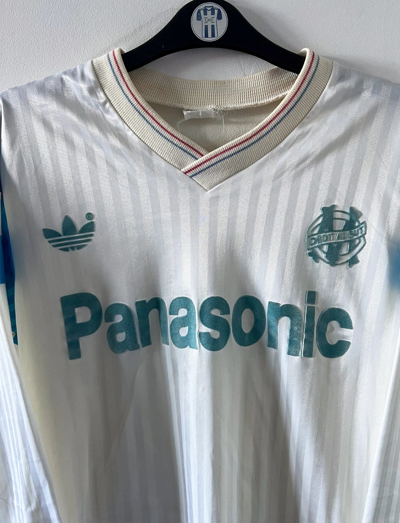 Maillot foot vintage domicile blanc de l'OM 1989/1991. On peut retrouver l'équipementier Adidas et le sponsor Panasonic. Il s'agit d'un maillot authentique d'époque.