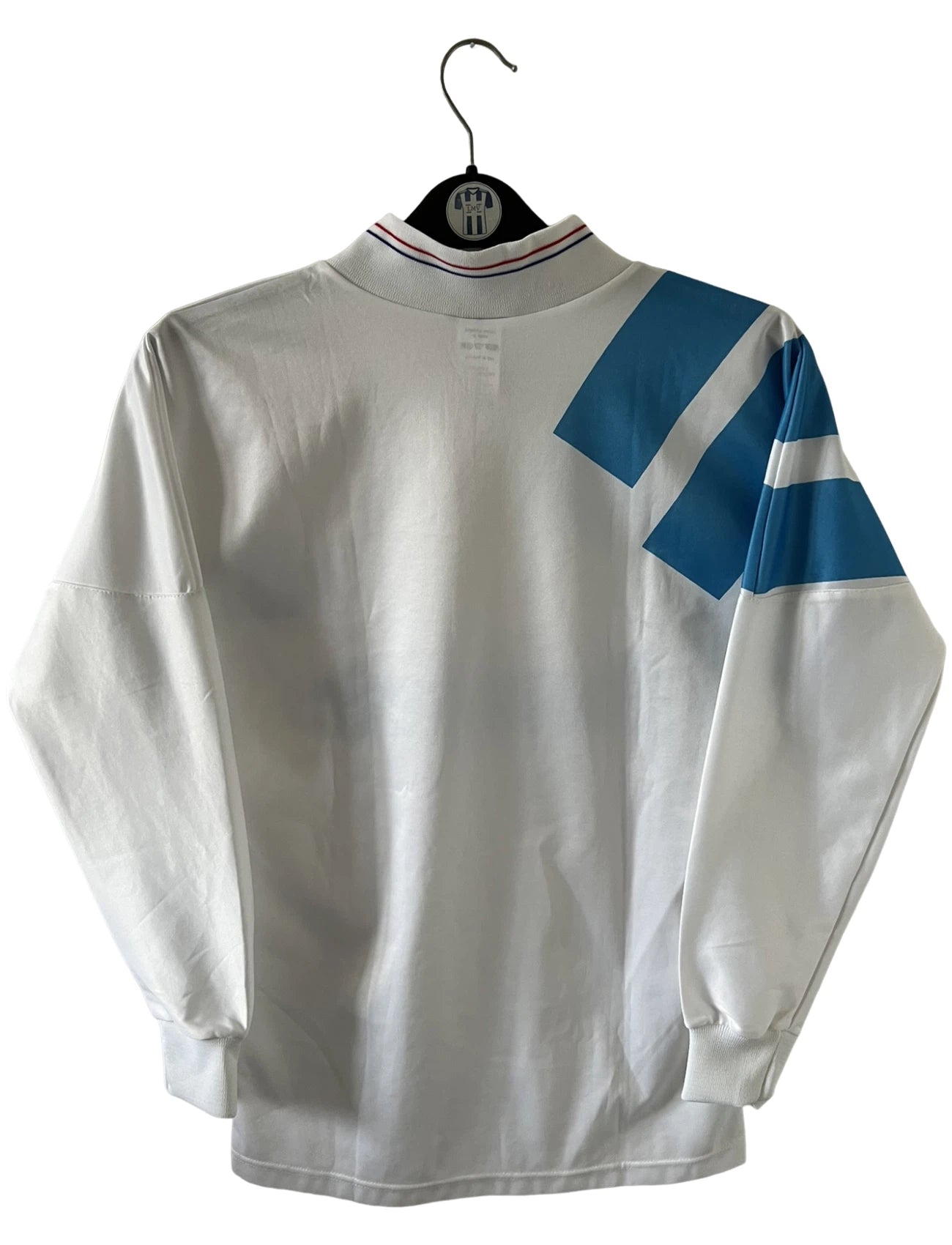 Maillot de foot vintage domicile blanc et bleu de la saison 1991/1992. On peut retrouver l'équipementier Adidas et le sponsor Panasonic. Il s'agit d'un maillot authentique d'époque.
