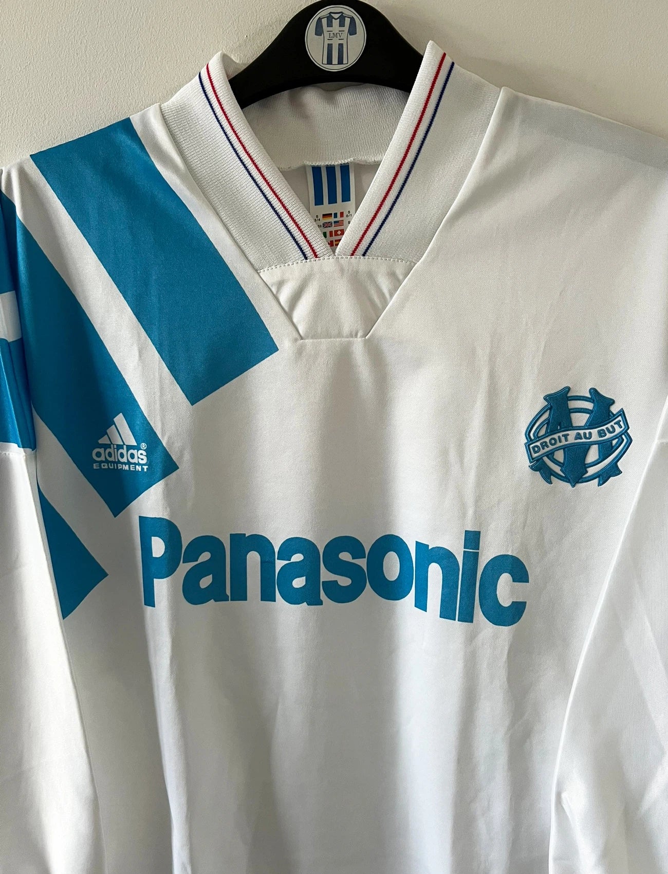 Maillot de foot vintage domicile blanc et bleu de la saison 1991/1992. On peut retrouver l'équipementier Adidas et le sponsor Panasonic. Il s'agit d'un maillot authentique d'époque.