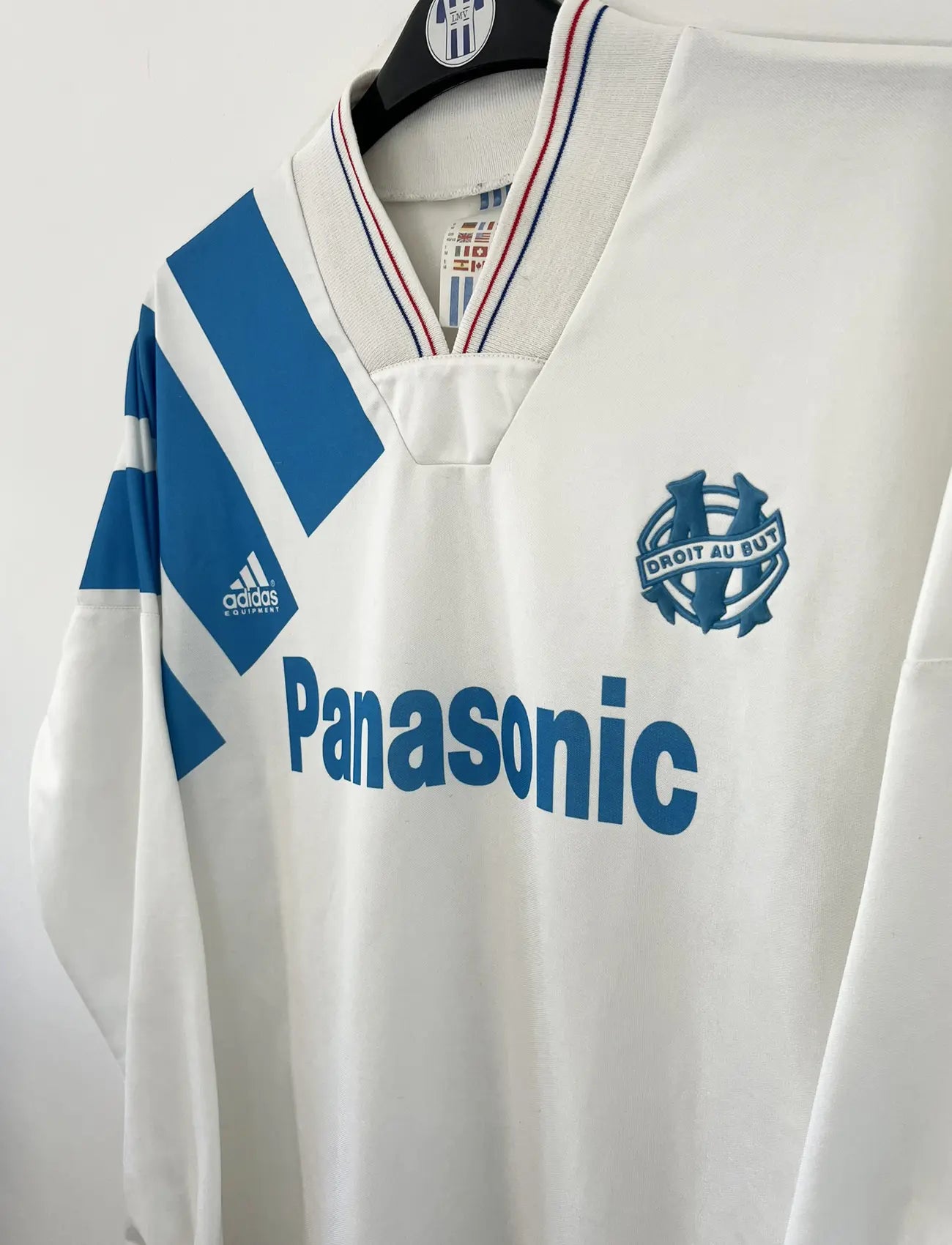 Maillot foot vintage domicile blanc et bleu de l'om de la saison 1991-1992. On peut retrouver l'équipementier adidas et le sponsor Panasonic. Il s'agit d'un maillot authentique d'époque.