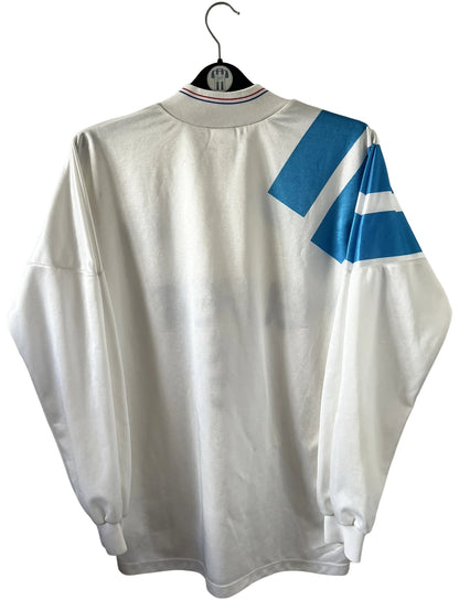Maillot de foot vintage domicile blanc et bleu de l'OM 1992/1993. On peut retrouver l'équipementier Adidas et le sponsor Eurest. Il s'agit d'un maillot authentique d'époque.