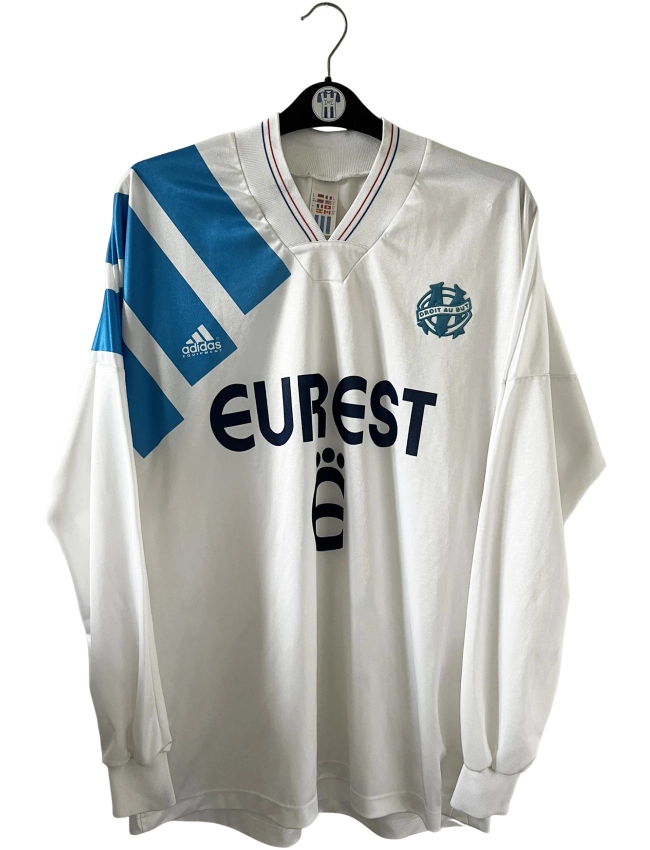 Maillot de foot vintage domicile OM 1992/1993. On peut retrouver l'équipementier Adidas et le sponsor Eurest. Il s'agit d'un maillot authentique d'époque.