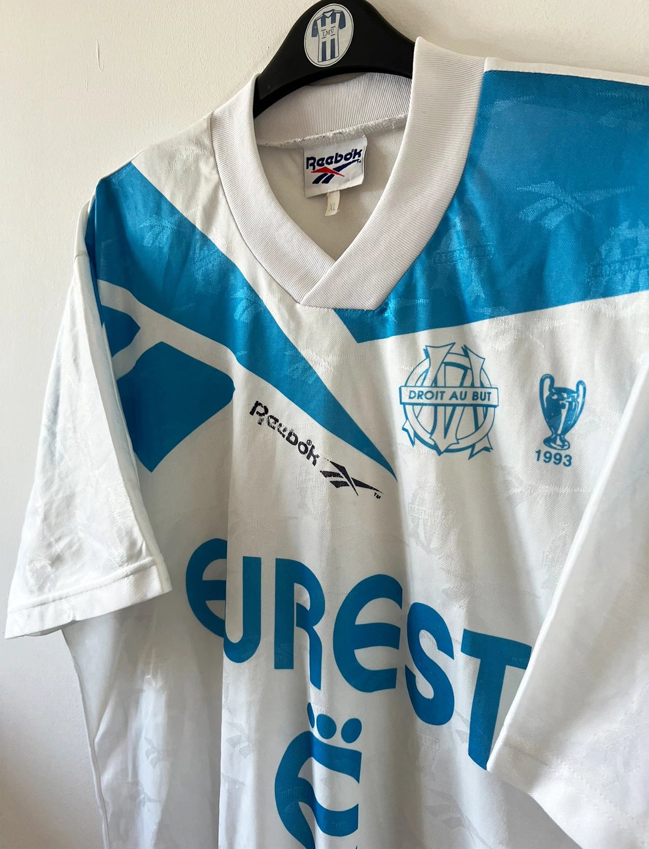 Maillot de foot vintage domicile blanc et bleu de l'OM 1994/1995. On peut retrouver l'équipementier Reebok et le sponsor Eurest. Il s'agit d'un maillot authentique d'époque.
