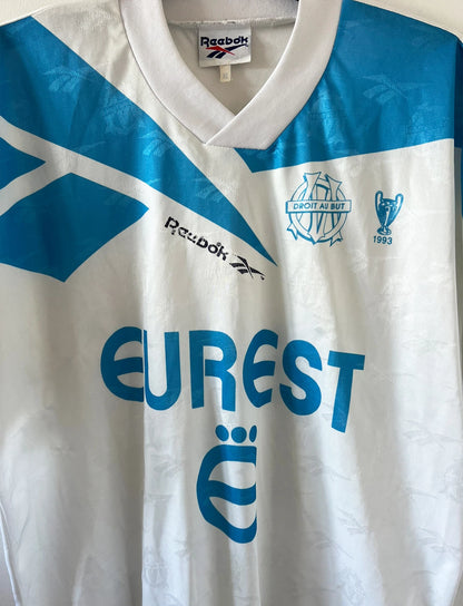 Maillot de foot vintage domicile blanc et bleu de l'OM 1994/1995. On peut retrouver l'équipementier Reebok et le sponsor Eurest. Il s'agit d'un maillot authentique d'époque.