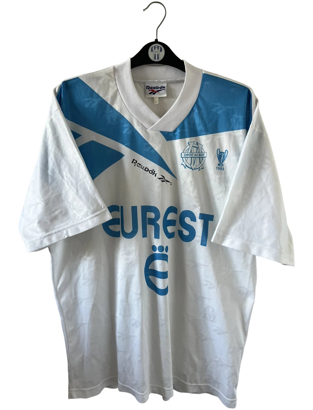 Maillot de foot vintage domicile blanc et bleu de l'OM 1994/1995. On peut retrouver l'équipementier Reebok et le sponsor Eurest. Il s'agit d'un maillot authentique d'époque.