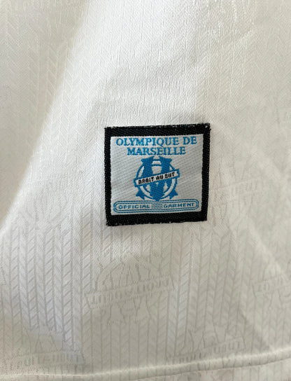 Maillot de foot vintage domicile blanc de l'OM 1997/1998. On peut retrouver l'équipementier Adidas et le sponsor Ericsson. Il s'agit d'un maillot authentique d'époque.