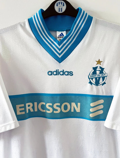Maillot de foot vintage domicile OM 1997/1998. On peut retrouver l'équipementier Adidas et le sponsor Ericsson. Il s'agit d'un maillot authentique d'époque.