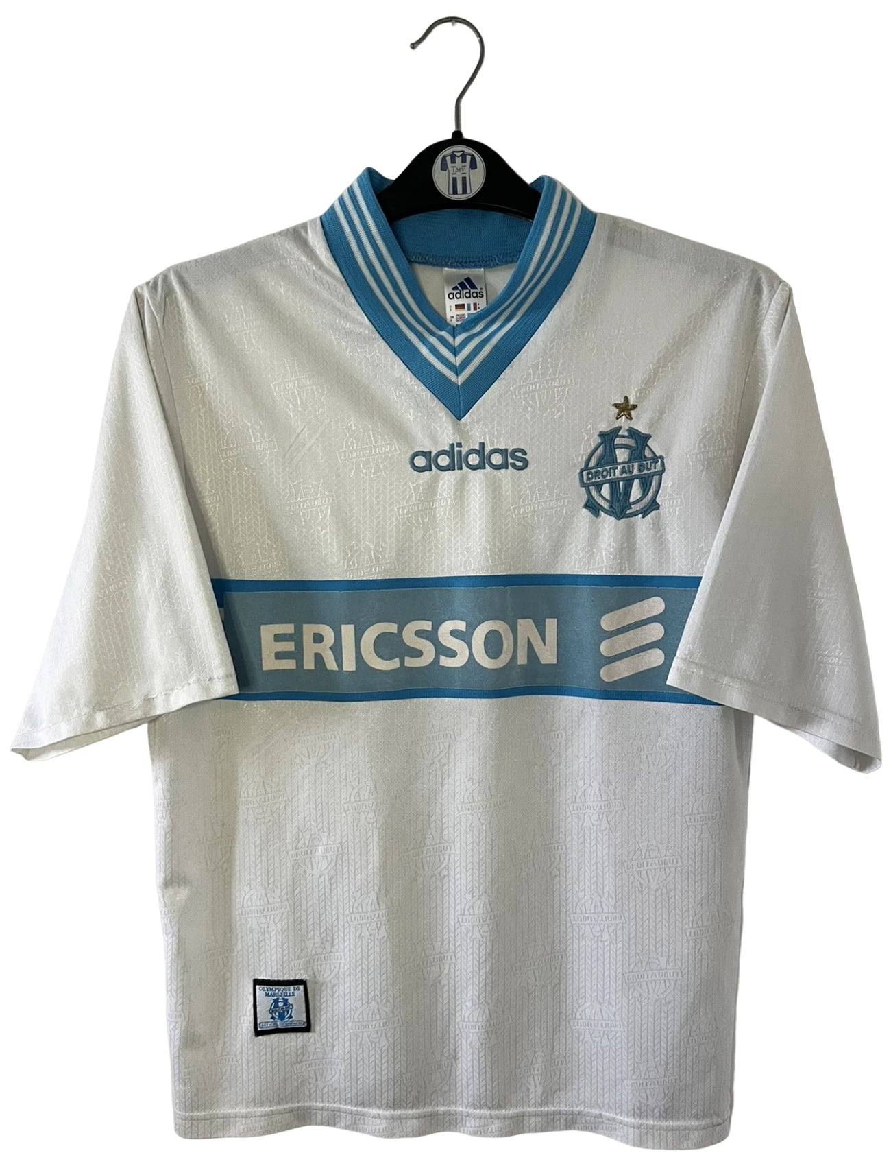 Maillot de foot vintage domicile blanc et bleu de l'OM saison 1997/1998. On peut retrouver l'équipementier Adidas et le sponsor Ericsson. Il s'agit d'un maillot authentique d'époque.
