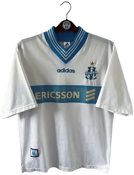 Maillot de foot vintage domicile OM 1997/1998. On peut retrouver l'équipementier Adidas et le sponsor Ericsson. Il s'agit d'un maillot authentique d'époque.
