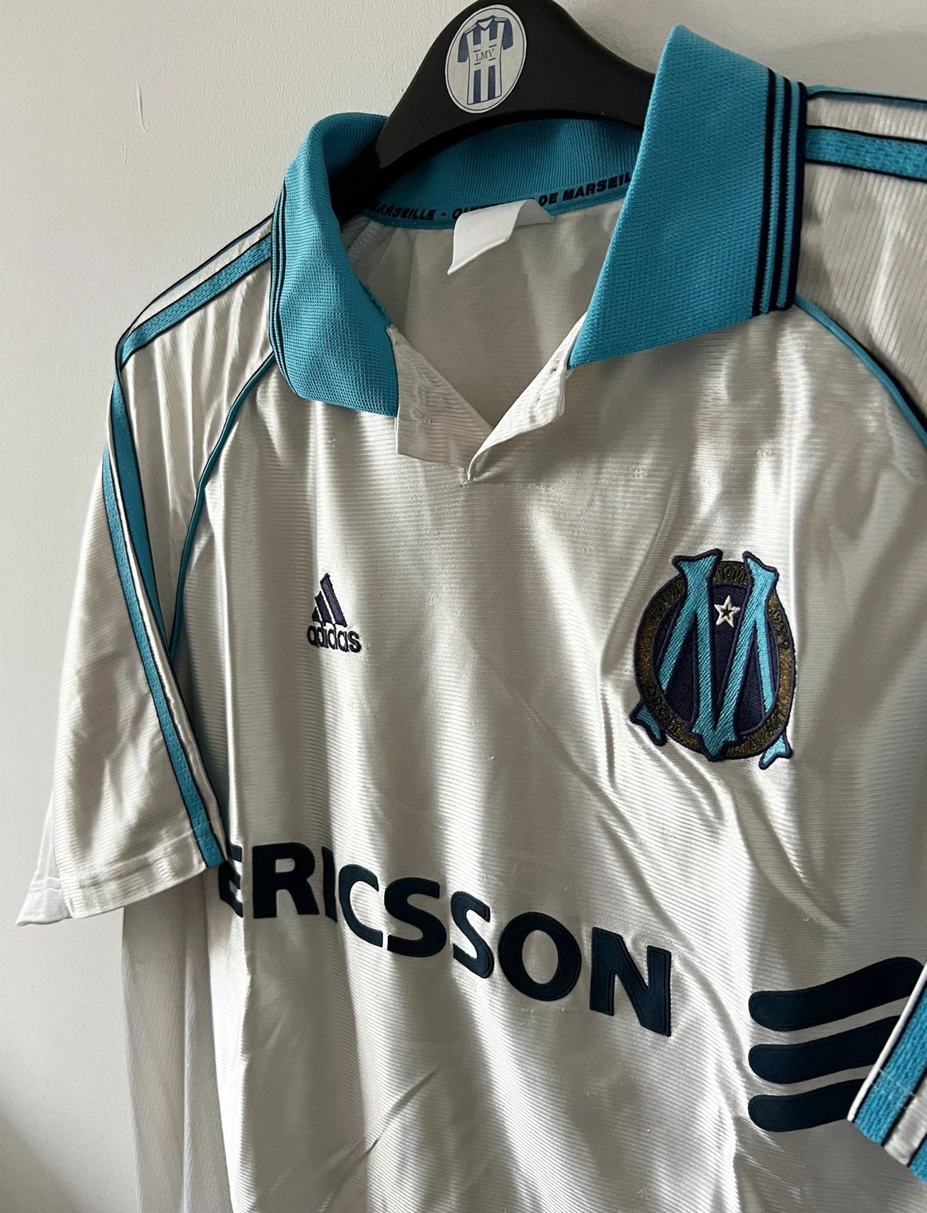 Maillot de foot vintage domicile blanc de l'OM 1998/1999. On peut retrouver l'équipementier Adidas et le sponsor Ericsson. Il s'agit d'un maillot authentique d'époque.