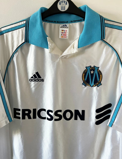 Maillot de foot vintage domicile blanc de l'OM 1998/1999. On peut retrouver l'équipementier Adidas et le sponsor Ericsson. Il s'agit d'un maillot authentique d'époque.