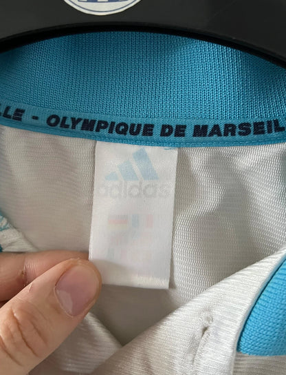 Maillot de foot vintage domicile blanc de l'OM 1998/1999. On peut retrouver l'équipementier Adidas et le sponsor Ericsson. Il s'agit d'un maillot authentique d'époque.