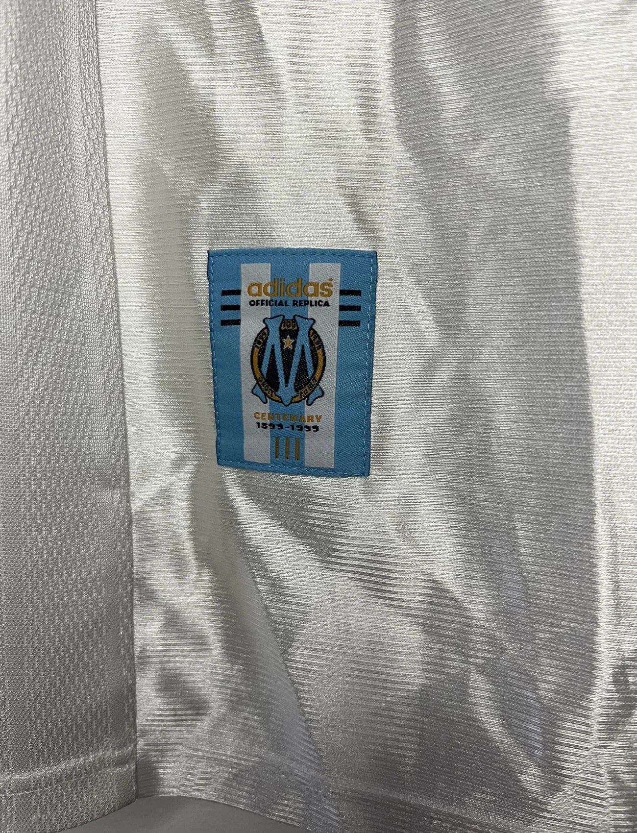 Maillot de foot vintage domicile de l'olympique de marseille de la saison 1998/1999. On peut retrouver l'équipementier Adidas et le sponsor Ericsson. Il s'agit d'un maillot authentique d'époque.