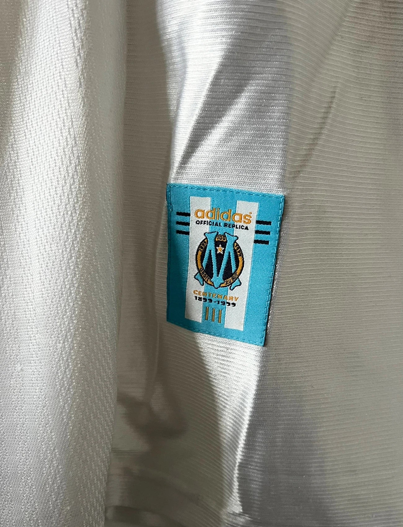 Maillot de foot vintage domicile blanc de l'OM 1998/1999. On peut retrouver l'équipementier Adidas et le sponsor Ericsson. Il s'agit d'un maillot authentique d'époque.