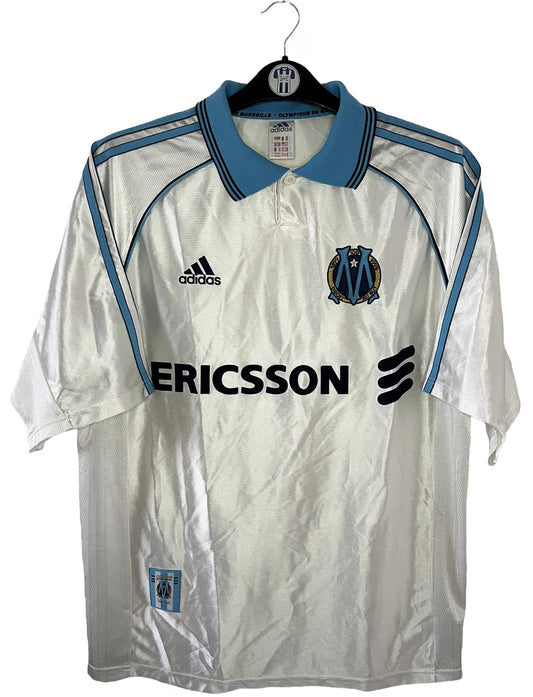 Maillot de foot vintage domicile de l'olympique de marseille de la saison 1998/1999. On peut retrouver l'équipementier Adidas et le sponsor Ericsson. Il s'agit d'un maillot authentique d'époque.