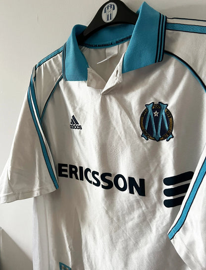 Maillot de foot vintage domicile blanc de l'OM 1998/1999. On peut retrouver l'équipementier Adidas et le sponsor Ericsson. Il s'agit d'un maillot authentique d'époque.