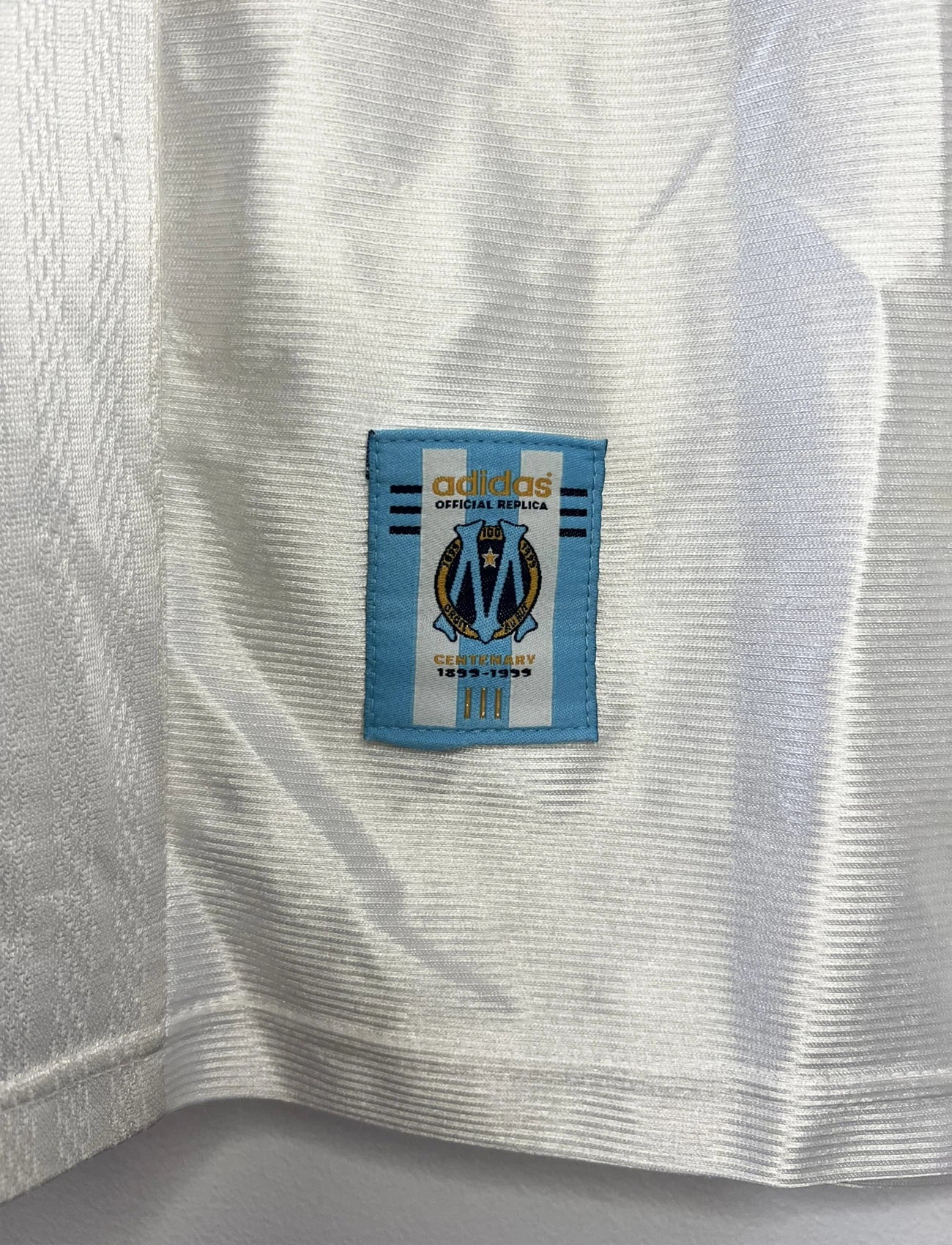 Maillot de foot vintage domicile blanc de l'OM de la saison 1998/1999. On peut retrouver l'équipementier Adidas et le sponsor Ericsson. Il s'agit d'un maillot authentique d'époque.