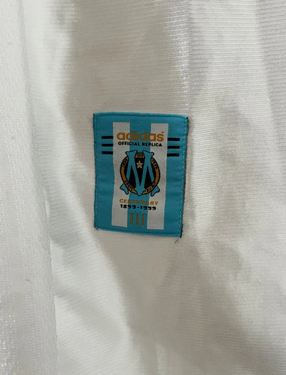 Maillot de foot vintage domicile blanc de l'OM 1998/1999. On peut retrouver l'équipementier Adidas et le sponsor Ericsson. Il s'agit d'un maillot authentique d'époque.