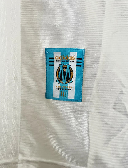 Maillot de foot vintage domicile de l'OM de la saison 1998/1999. On peut retrouver l'équipementier Adidas et le sponsor Ericsson. Le maillot est floqué du numéro 7 Robert Pirès. Il s'agit d'un maillot authentique d'époque.